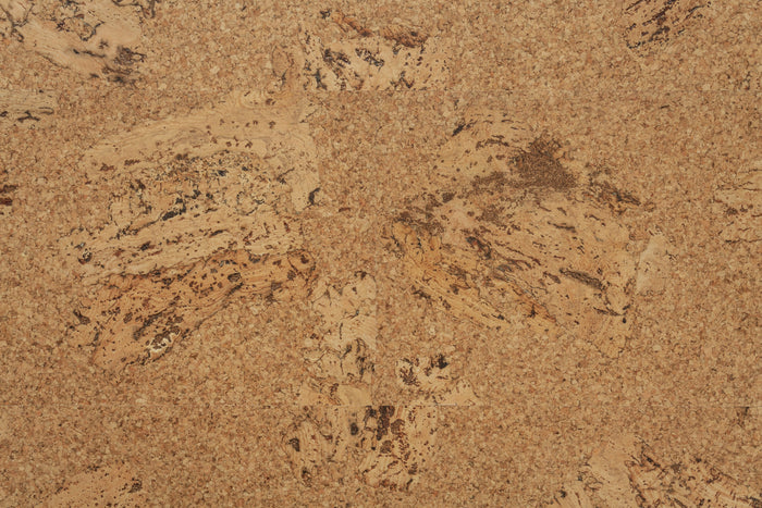 Wicanders Cork Go Originals Accent close-up of a cork material sample showing a natural tan and brown textured surface with darker speckled inclusions.
